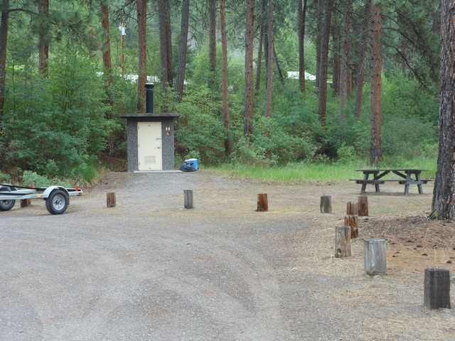 picture showing Picnic site with latrine in the background. Table does not meet accessibility standards. Path to latrine has a 4% slope for last 20'.