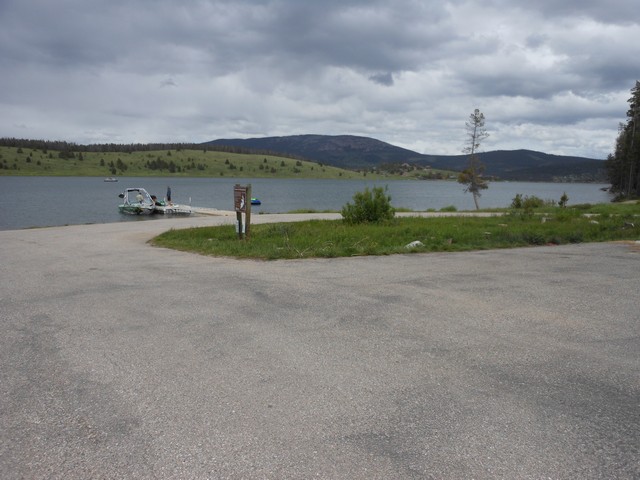 picture showing Boat ramp & dock has a large parking area to accommodate many boaters.  There are 2 disabled parking spots (painted symbols are very faded) down close to ramp.