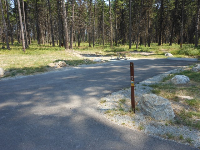 picture showing Campsite #16 E is one of 6 campsites in the group camping area.  Though campsites are not marked as accessible in this loop, this site has slopes and cross-slopes of around 1-2%.  It has an accessible picnic table but the fire-grill is not accessible.