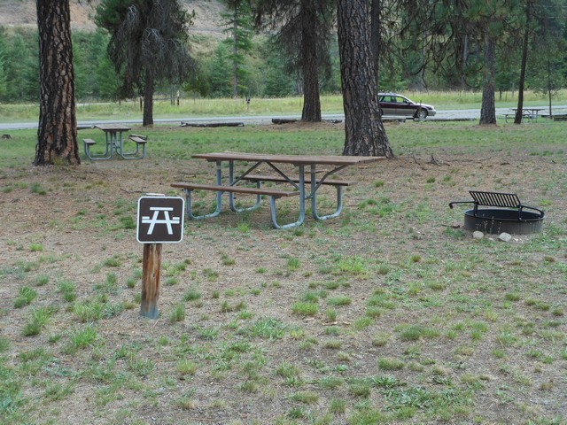 picture showing Picnic area with a couple of accessible tables.  This is in loop A.  The ground is natural and therefore, a little bumpy and uneven.