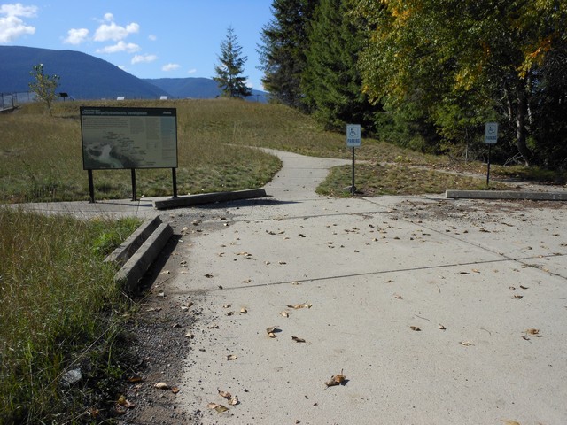 picture showing Accessible parking.  Sidewalk in the background leads to the overlook.