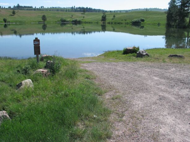 picture showing Gravel boat launch area.  Picture also shows most of the lake and the open, meadow-like lake shore that surrounds most of the lake.