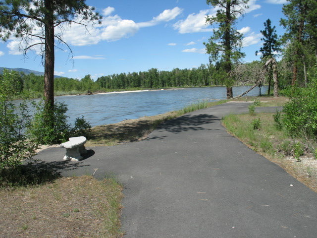 picture showing The river overlook at the end of the paved path.  There is a bench and large paved area.