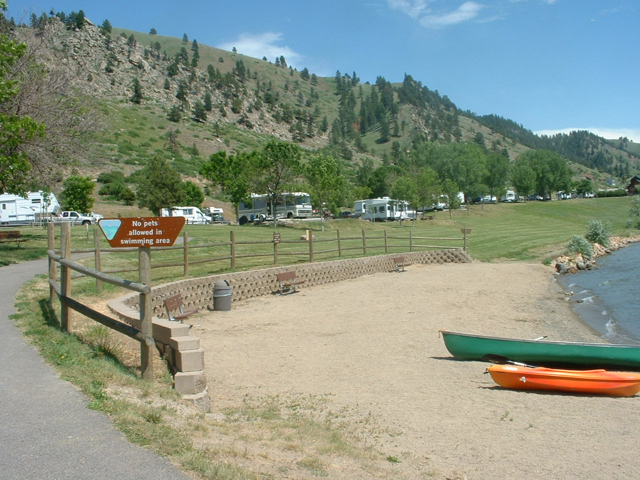 picture showing Swimming beach and some of the path to the swimming area and shore picnic tables.